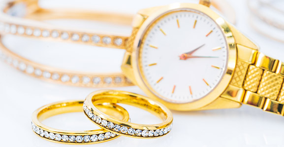 Luxury gold ring and lady gold watch on white